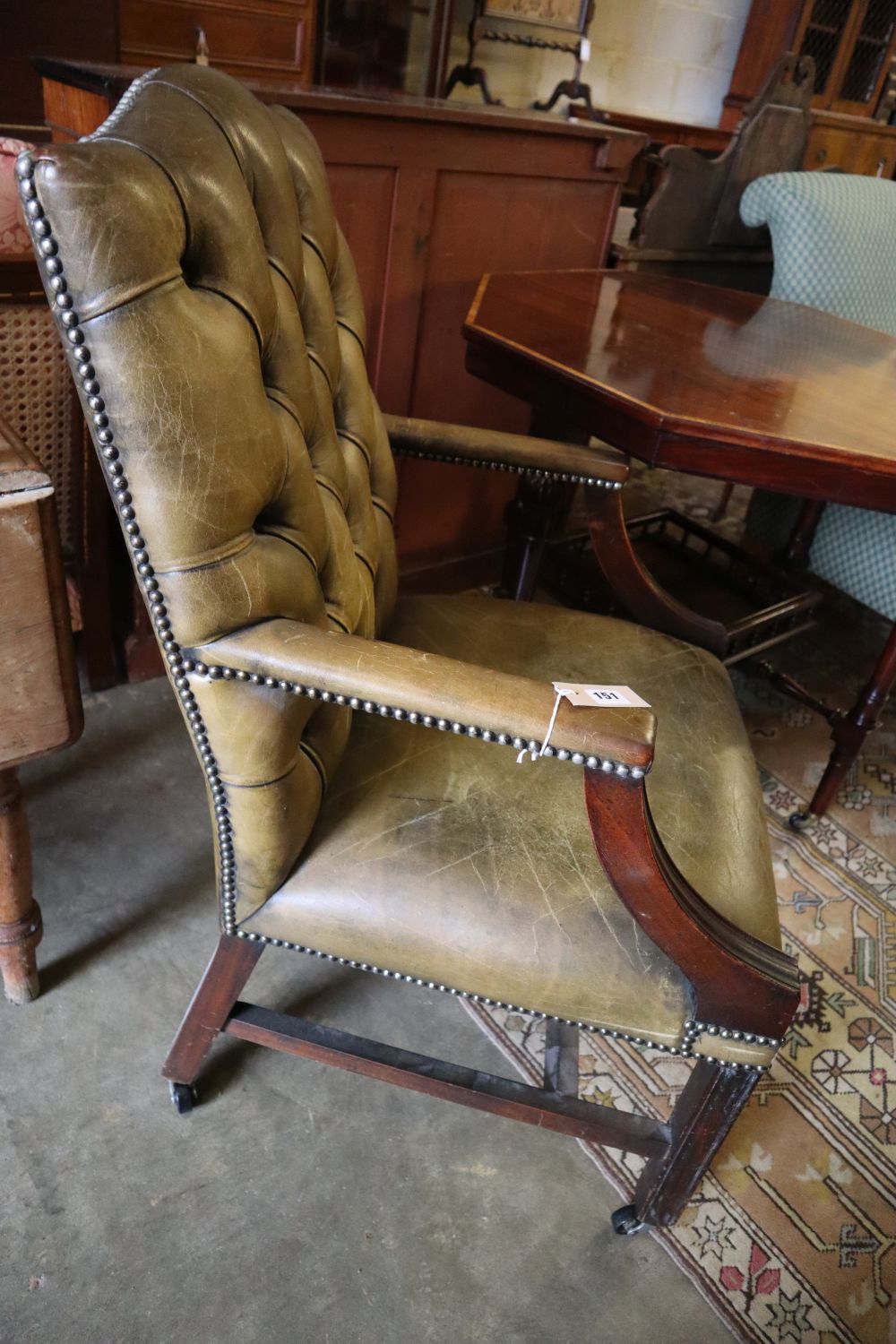 A George III style mahogany library chair, upholstered in buttoned green leather, width 58cm height 100cm